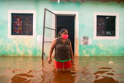 MEX2055. TECOCH (MÉXICO), 03/06/2020.- Una mujer sale de su vivienda inundada este miércoles en la Zona Norponiente del municipio de Tecoch, en el estado de Yucatán (México), tras el paso de la tormenta tropical Cristobal (Foto: EFE/ Cuauhtémoc Moreno)
