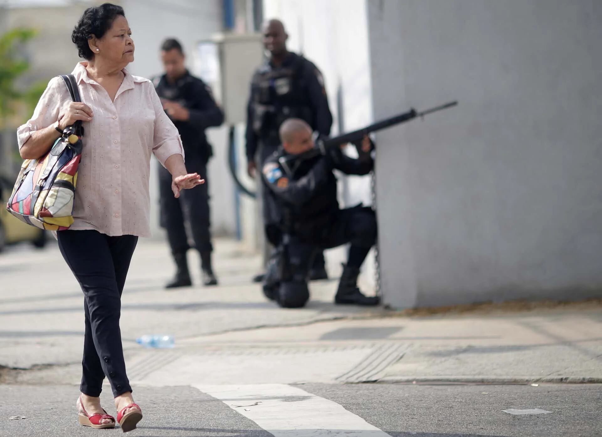 Una mujer camina por las calles mientras la policía ocupa sus posiciones durante un operativo contra el narcotráfico en Río de Janeiro, Brasil