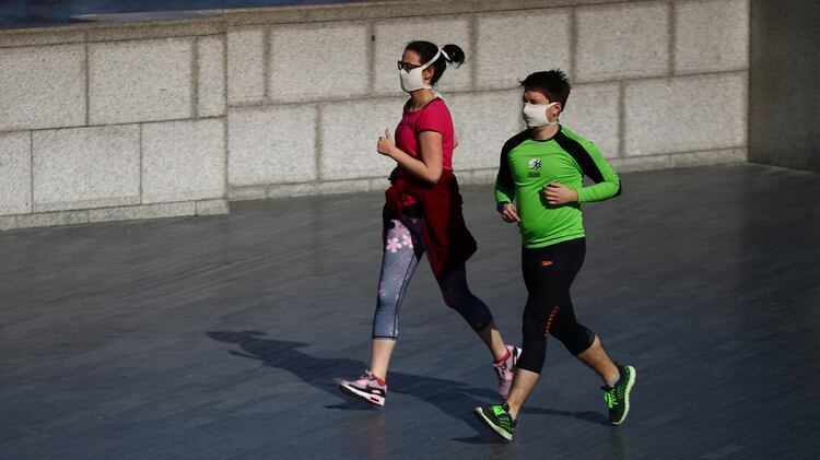 La gente corre con máscaras protectoras a orillas del río Támesis, mientras continúa la propagación de la enfermedad coronavirus (COVID-19), Londres