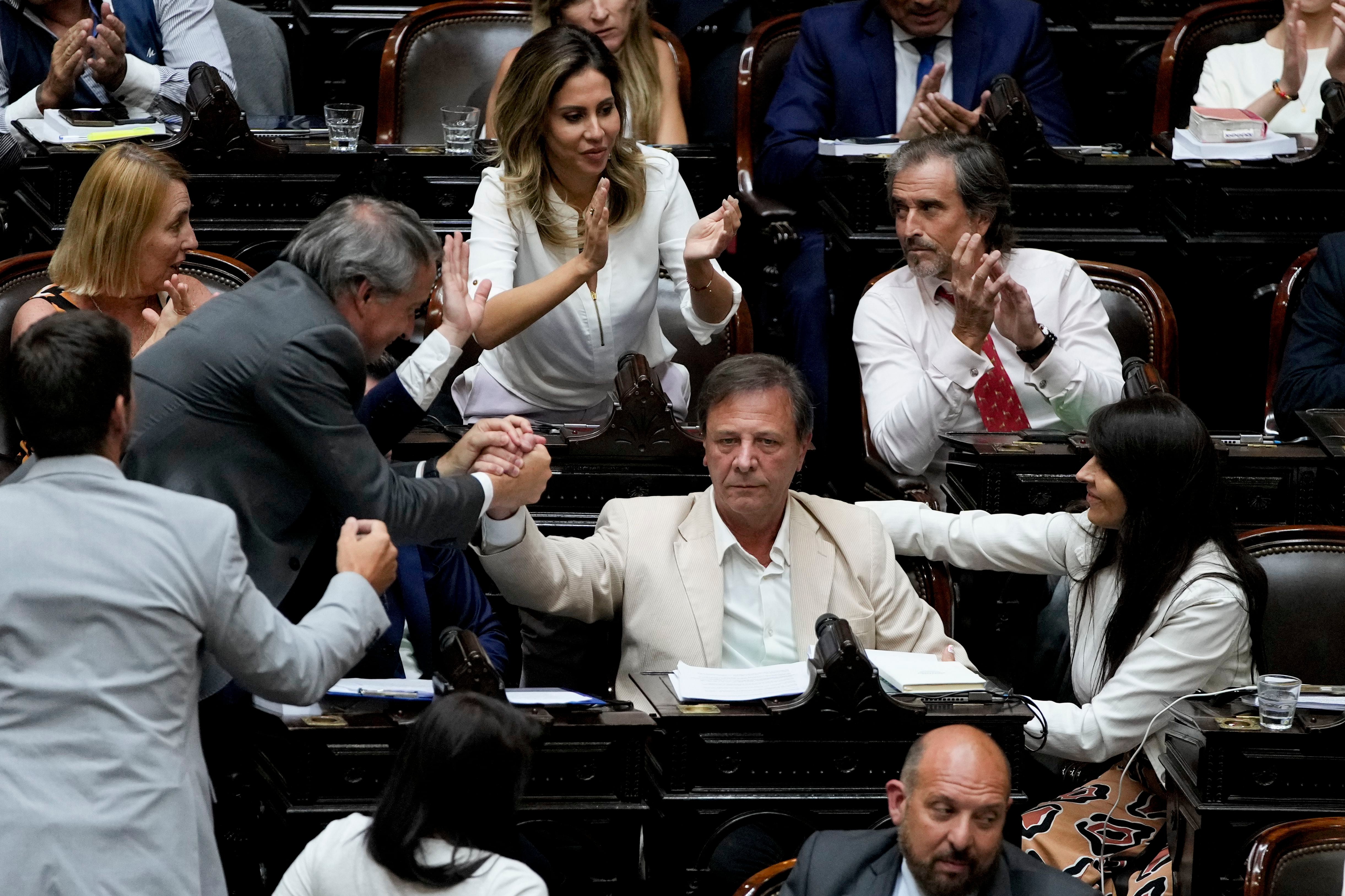 El legislador Óscar Zago recibe felicitaciones por su intervención durante el debate de la reforma económica del presidente argentino Javier Milei que fue aprobada en general por la Cámara de Diputados, en Buenos Aires, Argentina, el viernes 2 de febrero de 2024. La reforma, que incluye una variedad de medidas económicas, administrativas, penales y hasta medioambientales, debe ahora ser debatida artículo por artículo antes de ser enviada al Senado. (AP Foto/Natacha Pisarenko)