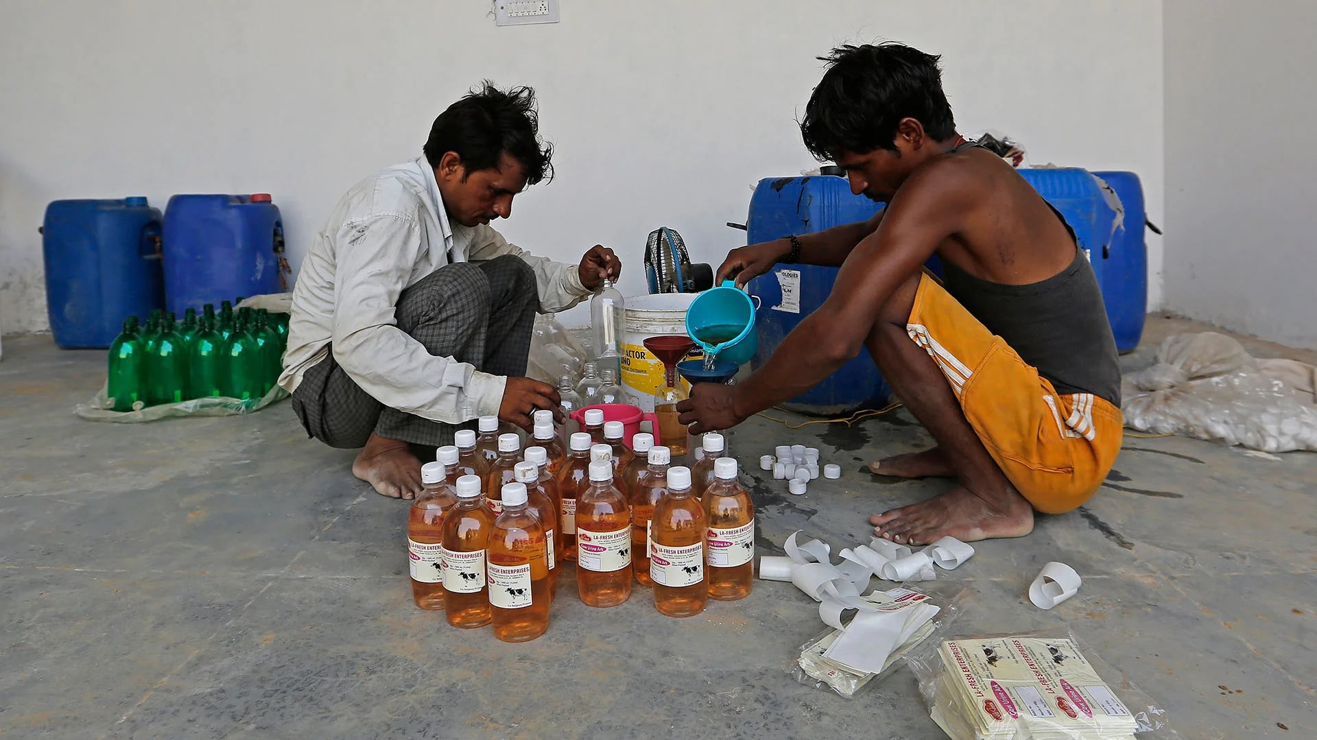Trabajadores llenan botellas con el producto destilado en Greater Noida, Uttar Pradesh, India (Bloomberg)