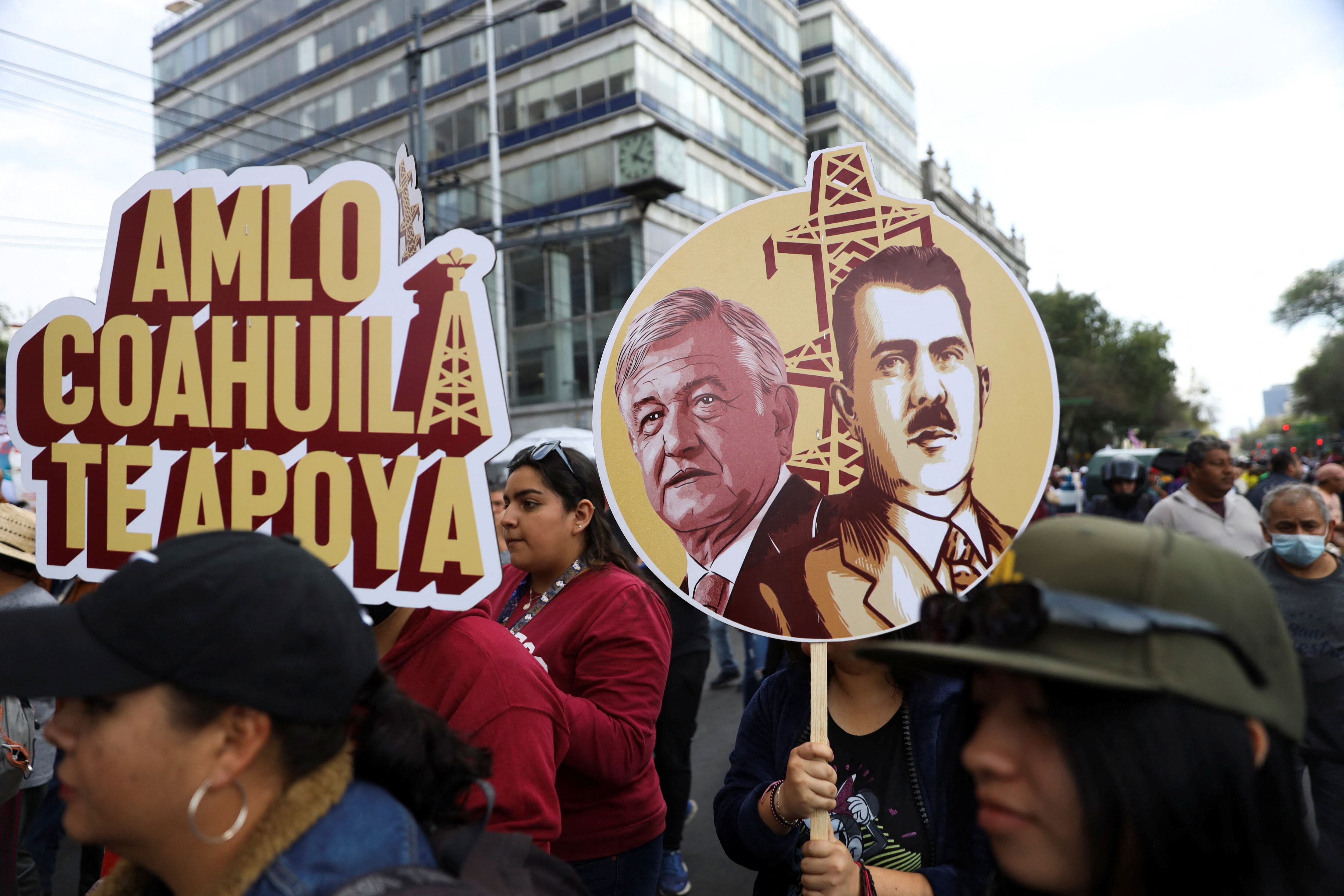 People hold signs with the images of Mexico's President Andres Manuel Lopez Obrador and late former Mexico's President Lazaro Cardenas and another one reading "AMLO, Coahuila supports you" during an event to mark the 85th anniversary of the expropriation of foreign oil, in Mexico City, Mexico March 18, 2023. REUTERS/Luis Cortes