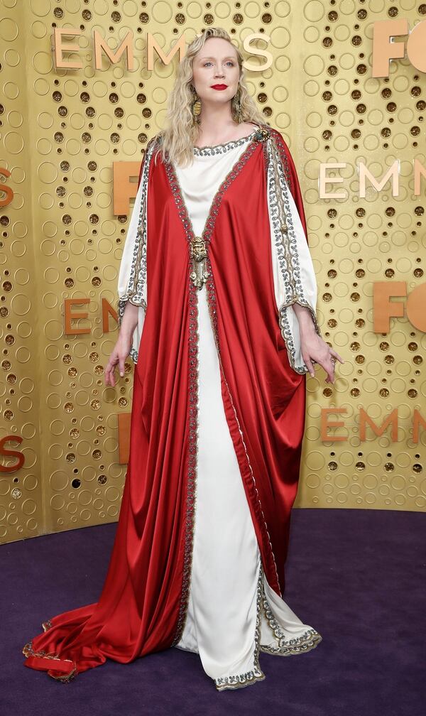Uno de los looks más llamativos de la alfombra violeta fue el de Gwendoline Christie que lució una túnica roja y blanca con detalles de bordado en  dorado
