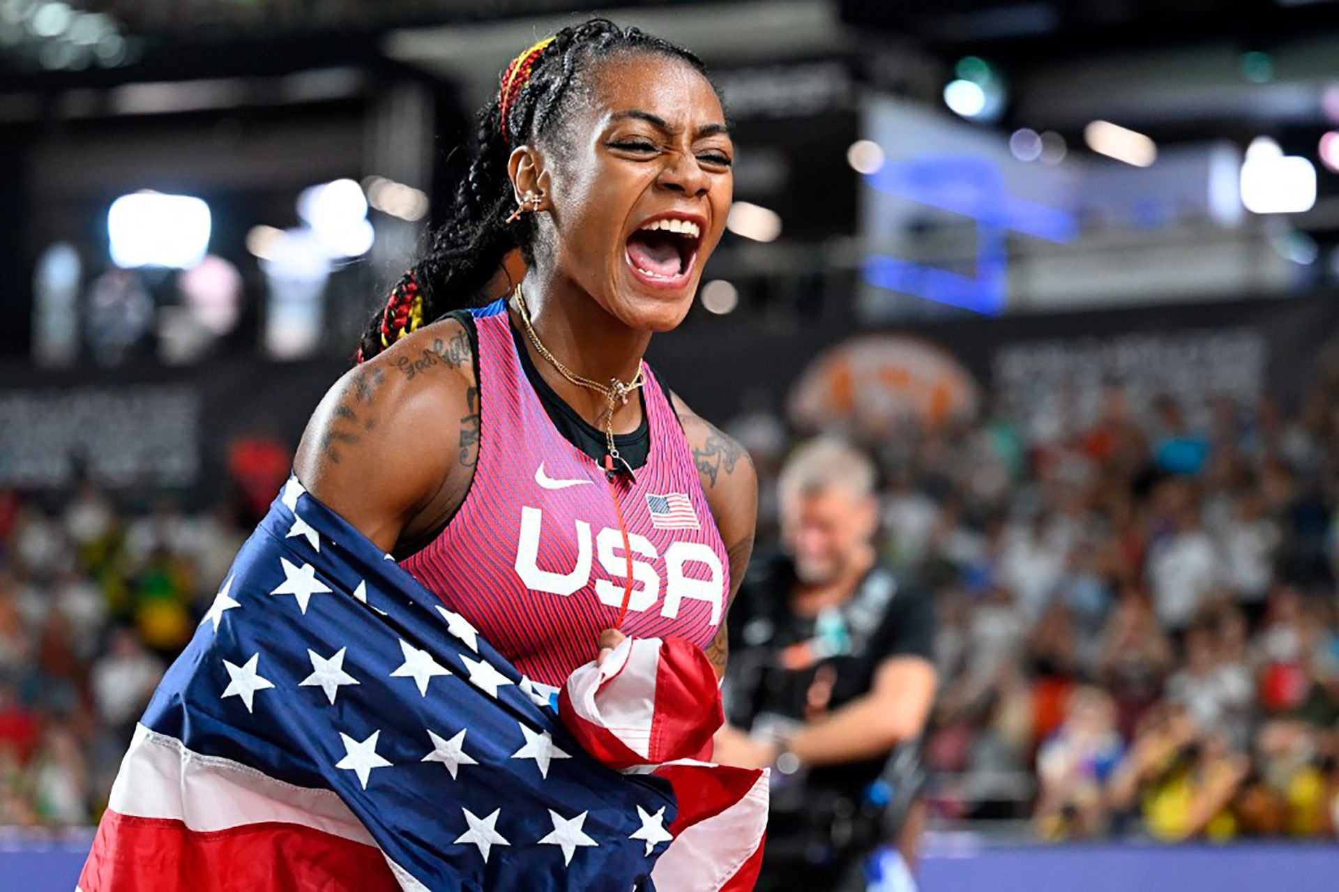 Sha'Carri Richardson con la bandera de los Estados Unidos tras ganar la carrera de los 100 metros en el Mundial de Atletismo (AFP)