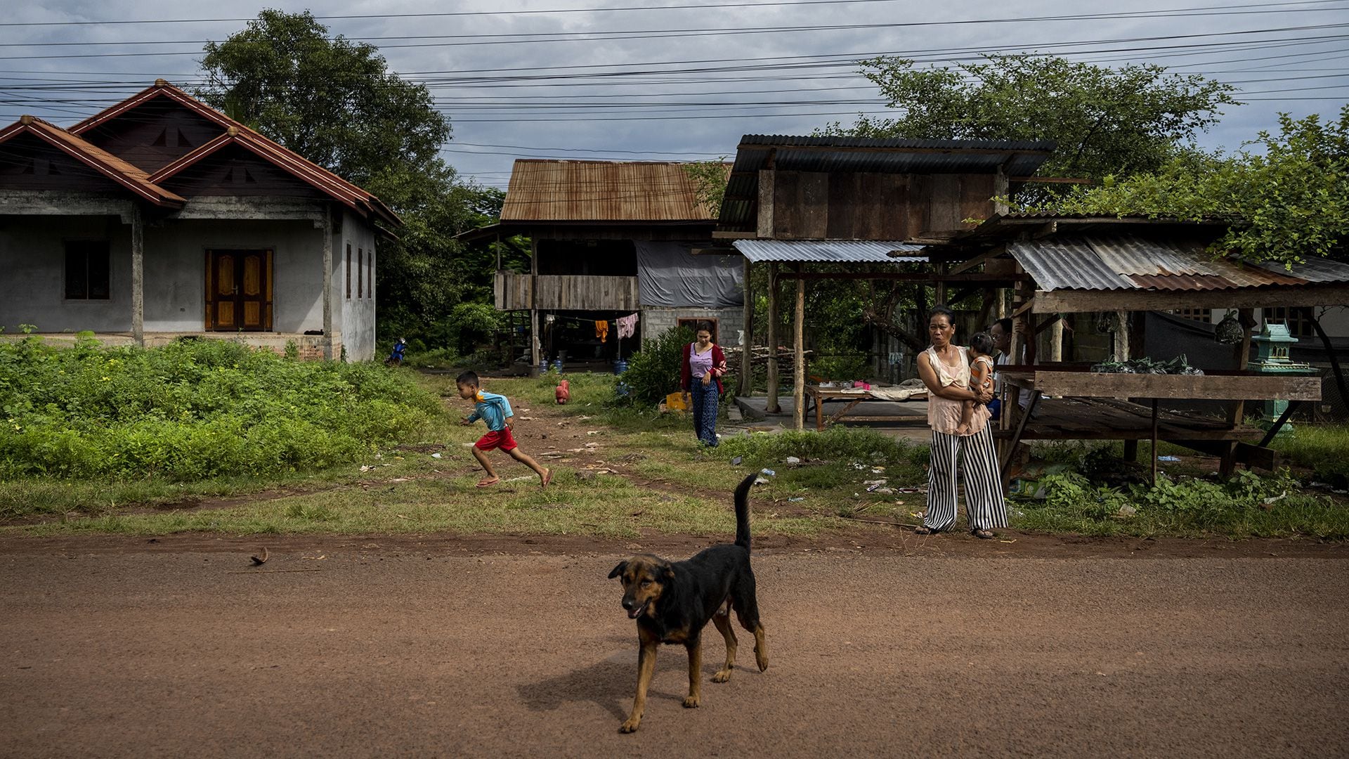 Personas y un perro son vistos en una pequeña aldea en la zona rural del sur de Laos el 19 de agosto de 2022 en Laos (Getty Images)