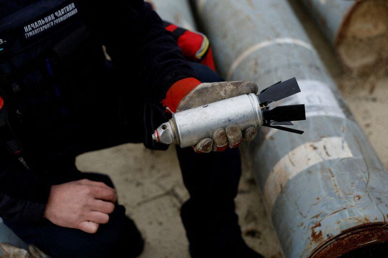 El militar ucraniano Igor Ovcharruck sostiene una bomba de racimo desactivada (REUTERS/Clodagh Kilcoyne/Foto de archivo)