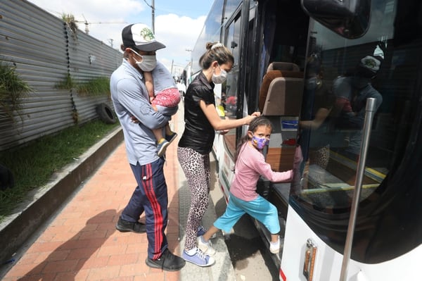 Migrantes venezolanos suben a un autobús con destino a la frontera venezolana, en medio de la pandemia del nuevo coronavirus, en Bogotá, Colombia. (AP Foto/Fernando Vergara)