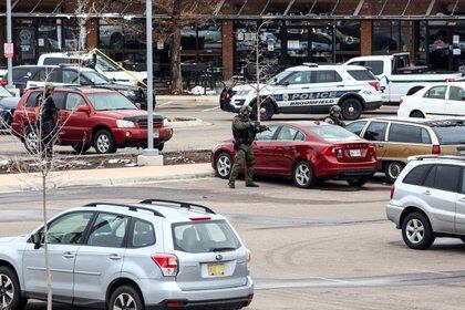 Agentes de la ley raastrean el estacionamiento en el lugar de un tiroteo en una tienda de comestibles King Soopers en Boulder (Reuters)