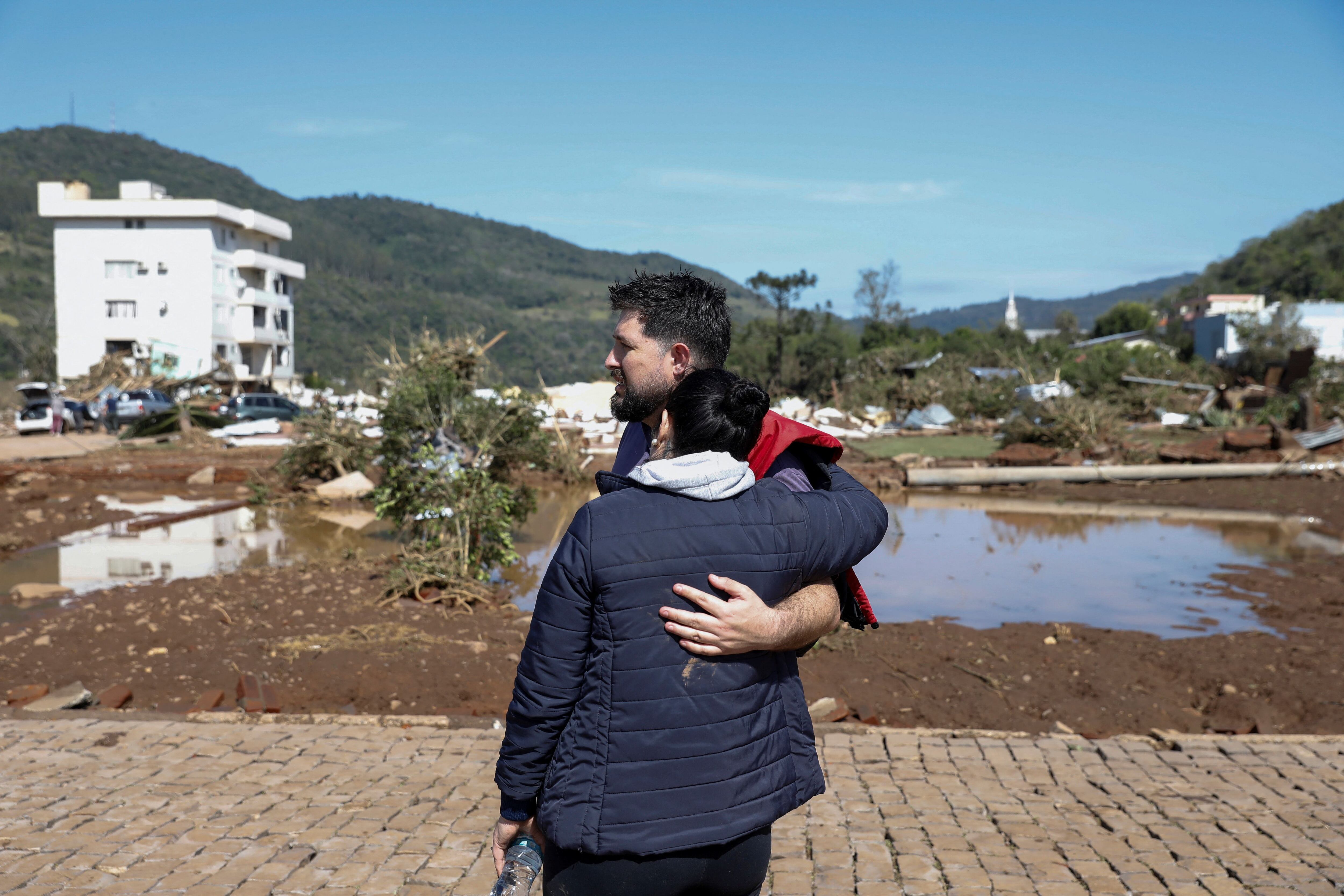 Dos personas se abrazan en medio de la destrucción   (REUTERS/Diego Vara)