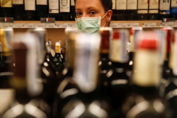 A woman wearing a protective mask lines up inside a liquour shop after Bangkok and several other provinces announced a 10-day ban on alcohol sale starting April 10 during the coronavirus disease (COVID-19) outbreak in Bangkok, Thailand, April 9, 2020. REUTERS/Jorge Silva
