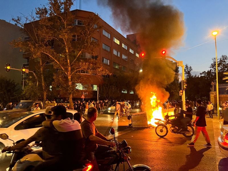 Una motocicleta de la policía arde durante una protesta por la muerte de Mahsa Amini, asesinada tras ser detenida por la "policía de la moral" de la república islámica, en Teherán (Reuters)