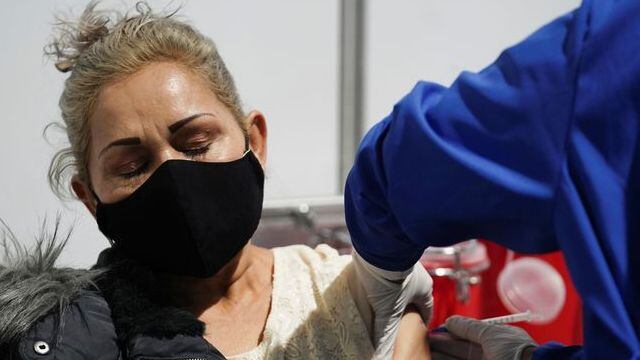 Foto de archivo. Una mujer recibe una vacuna contra el COVID-19 en el estacionamiento convertido en centro de vacunación, en Bogotá, Colombia, 8 de junio, 2021. REUTERS/Nathalia Angarita Foto de archivo. Una mujer recibe una vacuna contra el COVID-19 en el estacionamiento convertido en centro de vacunación, en Bogotá