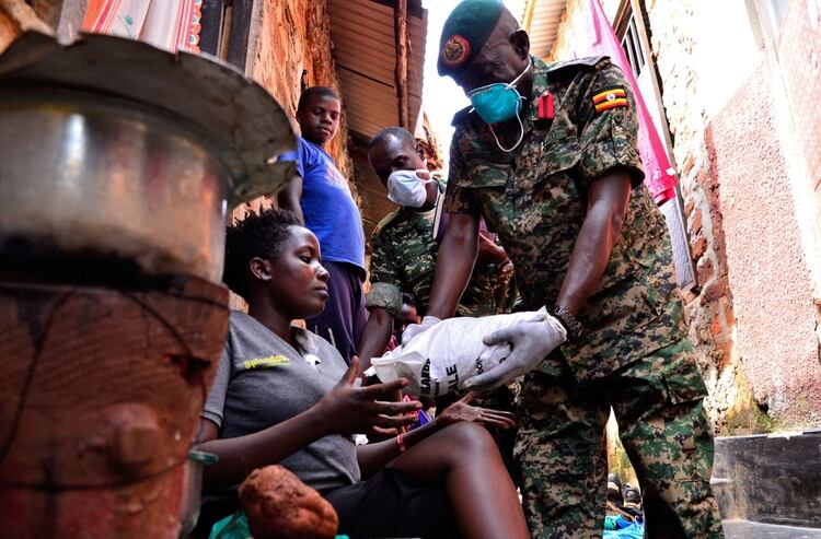 Una mujer recibe alimentos durante un ejercicio de distribución del Gobierno a los civiles afectados por la cuarentena, como parte de las medidas para prevenir la propagación del coronavirus, en Kampala, Uganda (Reuters/ Abubaker Lubowa)