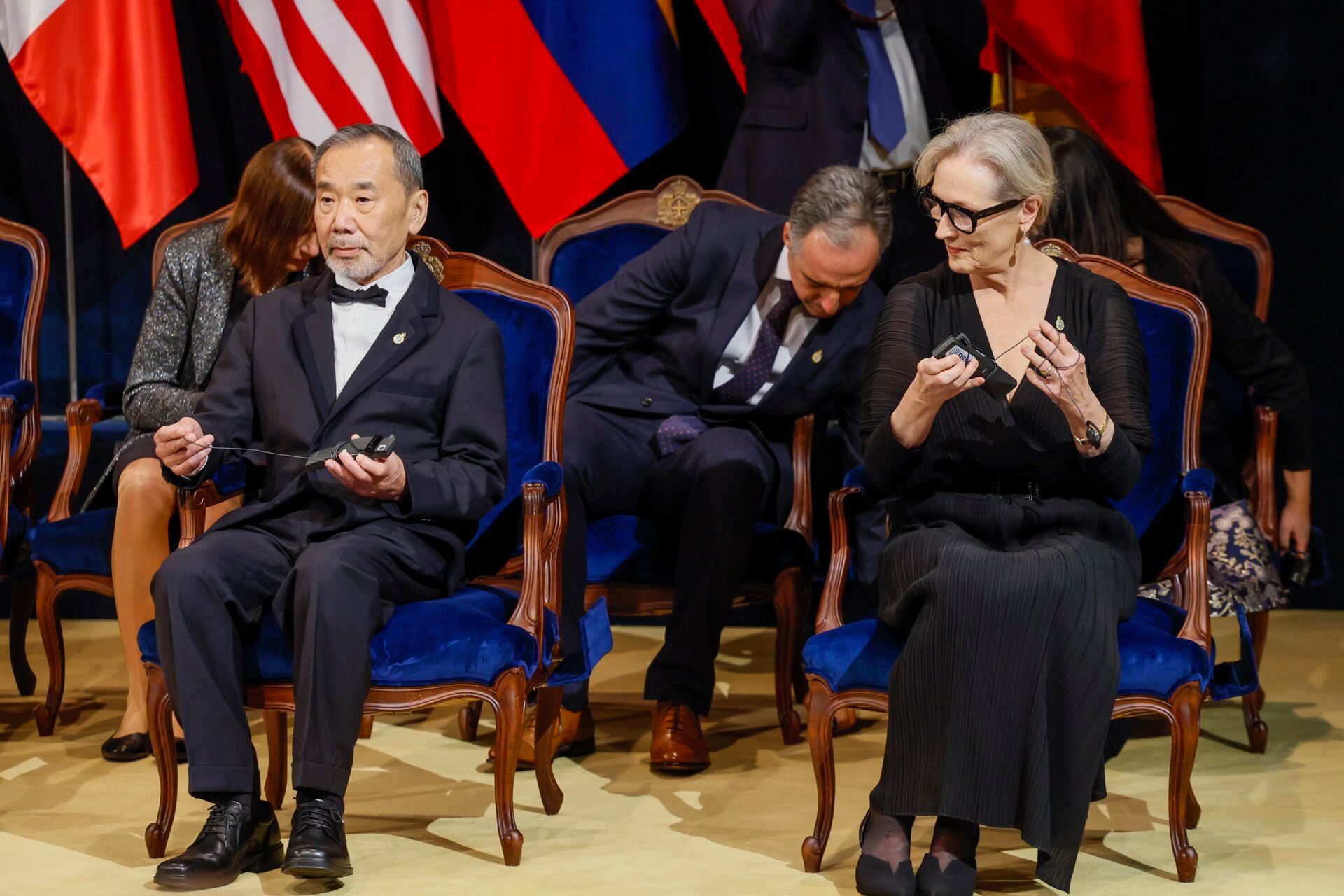 La actriz Meryl Streep (d), Premio Princesa de Asturias de las Artes y el escritor Haruki Murakami, Premio Princesa de Asturias de las Letras, se colocan los traductores simultáneos durante la 43º edición de los Premios Princesa de Asturias, este viernes en el Teatro Campoamor de Oviedo. EFE/ Ballesteros