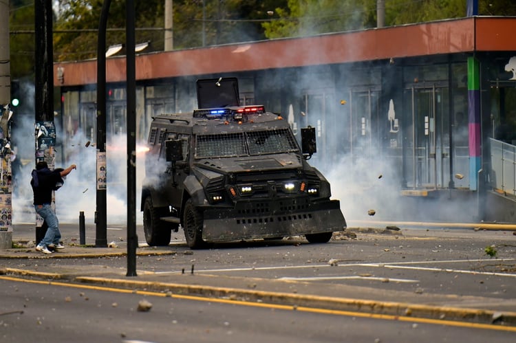 A protester clashes with riot police during a transport strike against the economic policies of the government of Ecuadorean President Lenin Moreno regarding the agreement signed on March with the International Monetary Fund (IMF), in Quito, on October 4, 2019. - The Ecuadorean government confirmed possible labour and tax reforms as established in the agreement, Economy Minister Richard Martinez stated -a day after announcing the elimination of fuel subsidies. (Photo by RODRIGO BUENDIA / AFP)