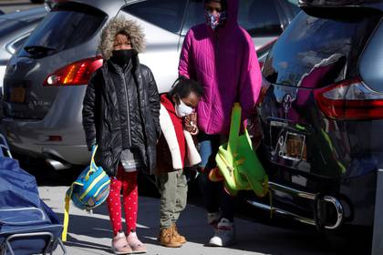 Niñas esperan en fila para recoger paquetes de comida gratis durante una operación de rescate de alimentos llevada a cabo por City Harvest durante el brote del COVID-19 en el distrito del Bronx de la ciudad de Nueva York el 22 de abril de 2020. REUTERS/Mike Segar