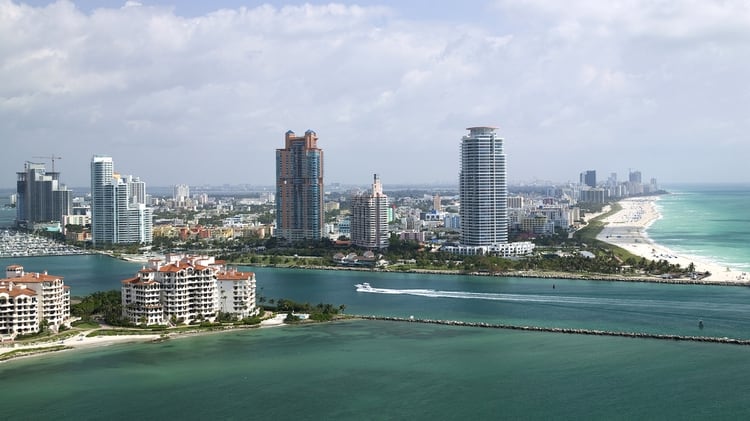 Fisher Island, en primer plano, frente a Miami Beach. Allí están refugiados del coronavirus decenas de multimillonarios y famosos. (Getty)