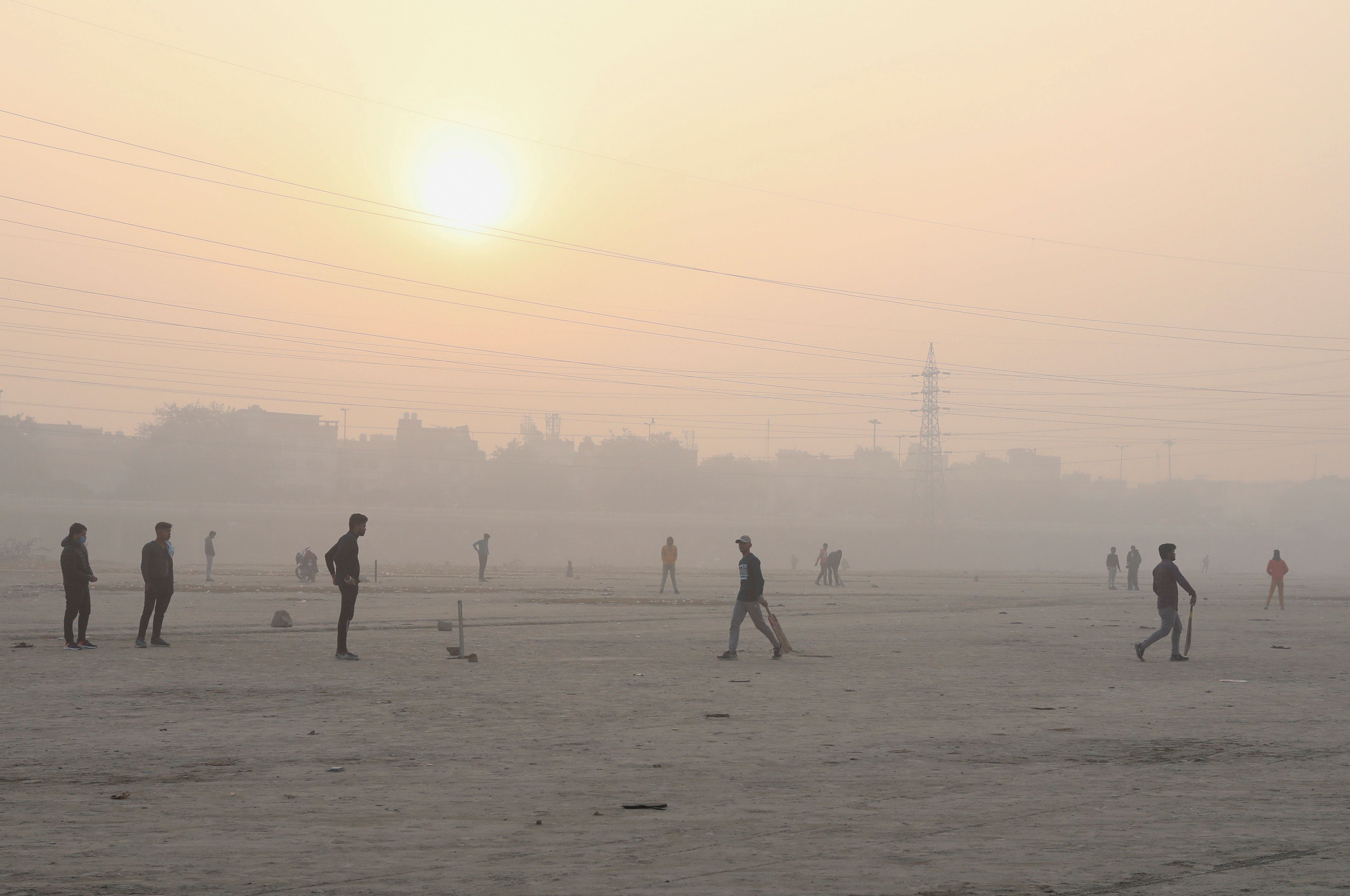 People play cricket on the floodplains of the Yamuna River on a foggy morning in New Delhi, India, on November 17, 2021. REUTERS / Anushree Fadnavis