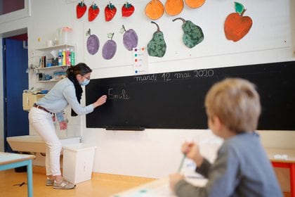 Una maestra, con una máscara protectora, enseña a alumnos en un aula de una escuela privada durante su reapertura en Saint-Sebastien-sur-Loire, cerca de Nantes, Francia (Reuters)