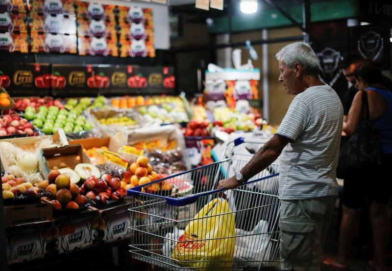 FOTO DE ARCHIVO: Un cliente espera con su carro de compras en una verdulería, en momentos en que la inflación argentina supera el 110% anual, en Buenos Aires. REUTERS/Agustin Marcarian