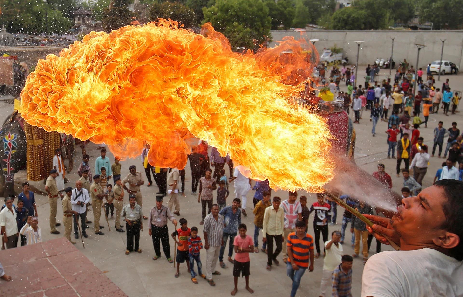 Un devoto hindú realiza un truco con fuego durante la procesión Jal Yatra antes de la anual Rath Yatra que se celebrará el 25 de junio en Ahmedabad, India