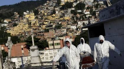 Sepultureros llevan el ataúd de Avelino Fernandes Filho, de 74 años, quien falleció por coronavirus en Río de Janeiro, Brasil. 18 de mayo de 2020 (REUTERS/Ricardo Moraes)