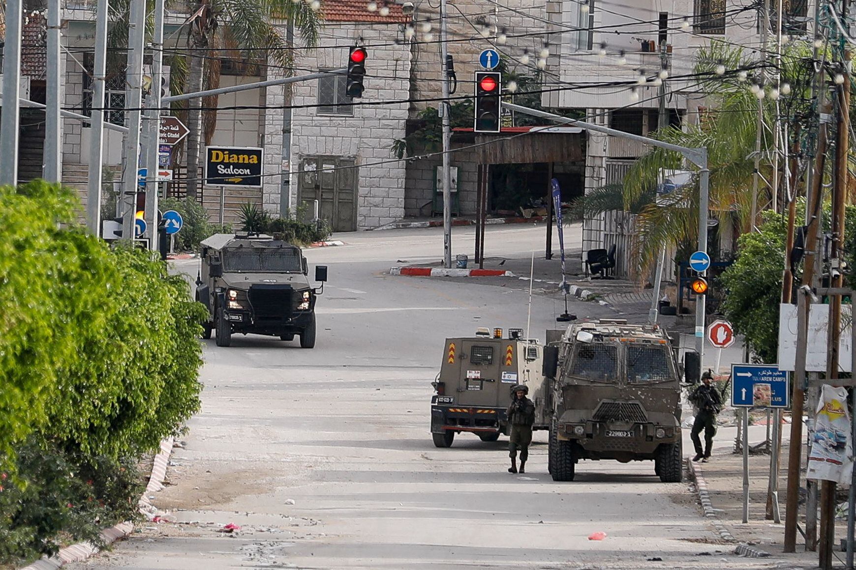 Soldados israelíes caminan junto a vehículos militares durante una redada en Tulkarm, en la Cisjordania ocupada por Israel, este miércoles. (REUTERS/Raneen Sawafta(