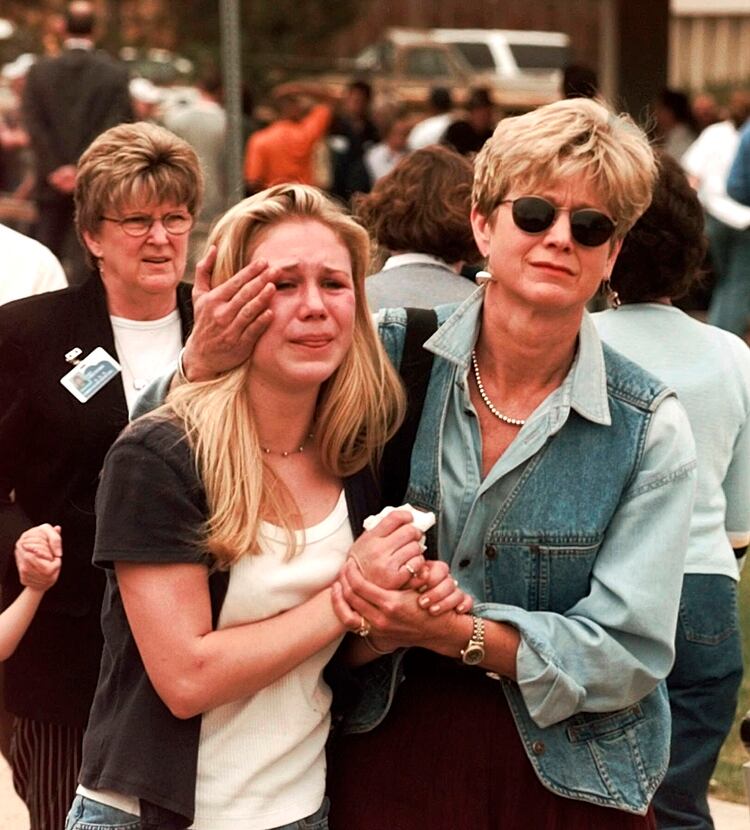 Una madre consuela a su hija, luego de que logró escapar de la masacre en la escuela de Columbine.