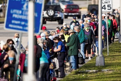 Cientos de personas esperan en fila en el Lakes Park Regional Library para recibir la vacuna COVID-19 en Fort Myers, Florida, EE.UU. 30 de diciembre de 2020. Fotografía tomada el 30 de diciembre de 2020. Andrew West / The News-Press / USA TODAY NETWORK vía REUTERS.