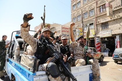 Tropas hutíes viajan en la parte trasera de una patrulla policial después de participar en una reunión en Sanaa, Yemen (Reuters)