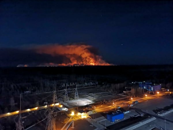 En esta imagen tomada desde la azotea de la central nuclear de Chernobyl, en Ucrania, el viernes 10 de abril de 2020, se ve un incendio forestal cerca de la planta en la zona de exclusión. (Oficina de Prensa de la Policía de Ucrania via AP)