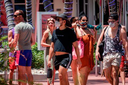 Personas usando tapabocas pasean por Ocean Drive en Miami Beach, Florida. EFE/Giorgio Viera
