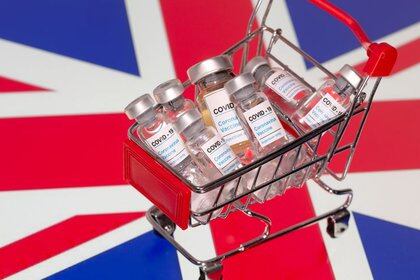 FILE PHOTO: A small shopping basket filled with vials labeled  "COVID-19 - Coronavirus Vaccine"  is placed on a UK flag in this illustration taken November 29, 2020. Picture taken November 29, 2020. REUTERS/Dado Ruvic/Ilustration/File Photo
