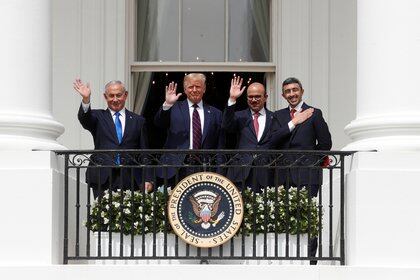 Los cuatro firmantes de los acuerdos saludan desde un balcón del jardín sur de la Casa Blanca. Foto: REUTERS/Tom Brenner 