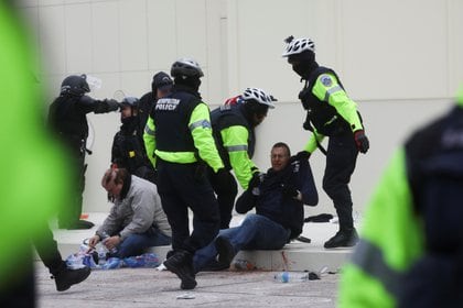 Un policía sostiene la camiseta de un hombre después de un enfrentamiento fuera del edificio del Capitolio REUTERS/Leah Millis