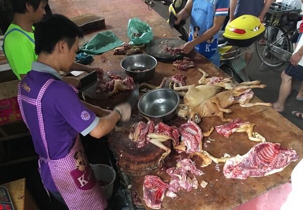 Vendedores preparando carne de perro durante el festival de Yulin (AFP)