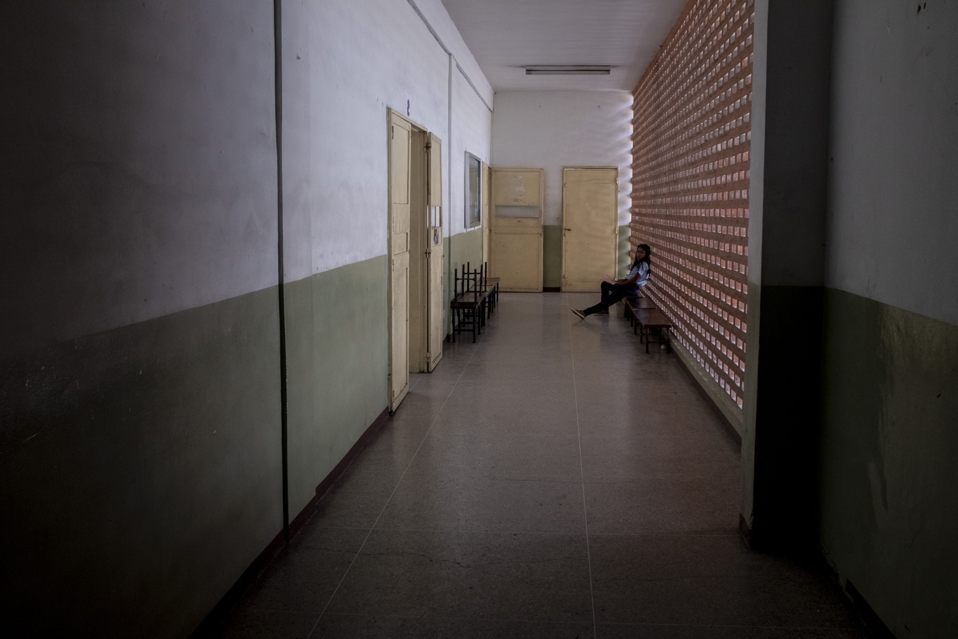 Un estudiante sentado en un pasillo de la escuela Cecilio Acosta en Los Teques (Bloomberg)