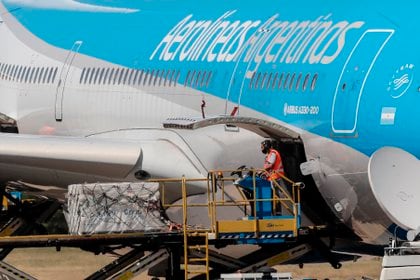 Operarios descargan de un avión de Aerolíneas Argentinas los primeros contenedores de la vacuna rusa Sputnik-V contra la covid-19, el 24 de diciembre de 2020, en el Aeropuerto de Ezeiza en Buenos Aires (Argentina). EFE/Juan Ignacio Roncoroni/Archivo 