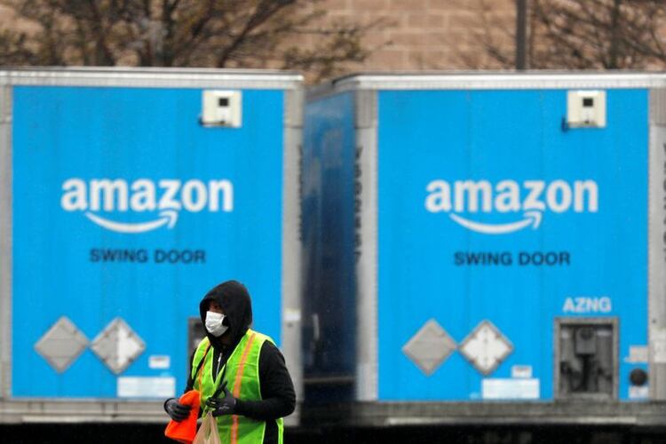 Imagen de archivo de un trabajador utilizando una mascarilla mientras camina entre camiones estacionados en una instalación de Amazon en medio de la epidemia del coronavirus, en Bethpage, Long Island, Nueva York, Estados Unidos. 17 de marzo, 2020. REUTERS/Andrew Kelly/Archivo