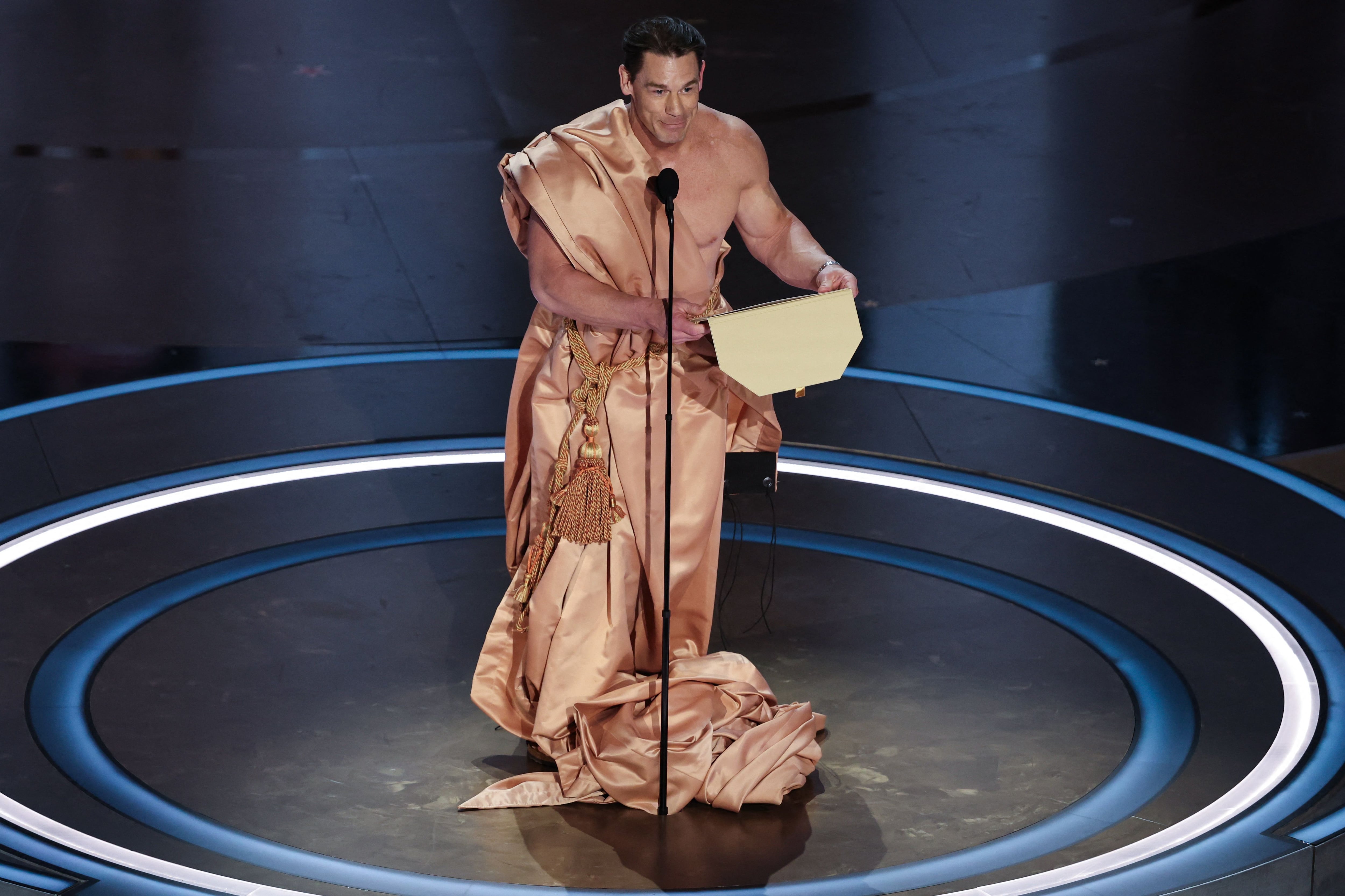 John Cena lució una especie de toga durante su divertida presentación en los Premios Oscars 2024 (REUTERS/Mike Blake)
