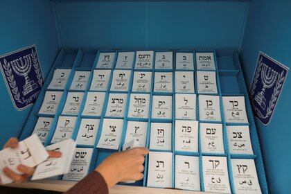 En Jerusalén, justo antes de la apertura de la mesa electoral para los israelíes en las elecciones generales israelíes, se emitió una boleta oficial en una cabina electoral móvil especial para los israelíes aislados o afectados por el virus corona (COVID-19).  REUTERS / Ronen Zvulun