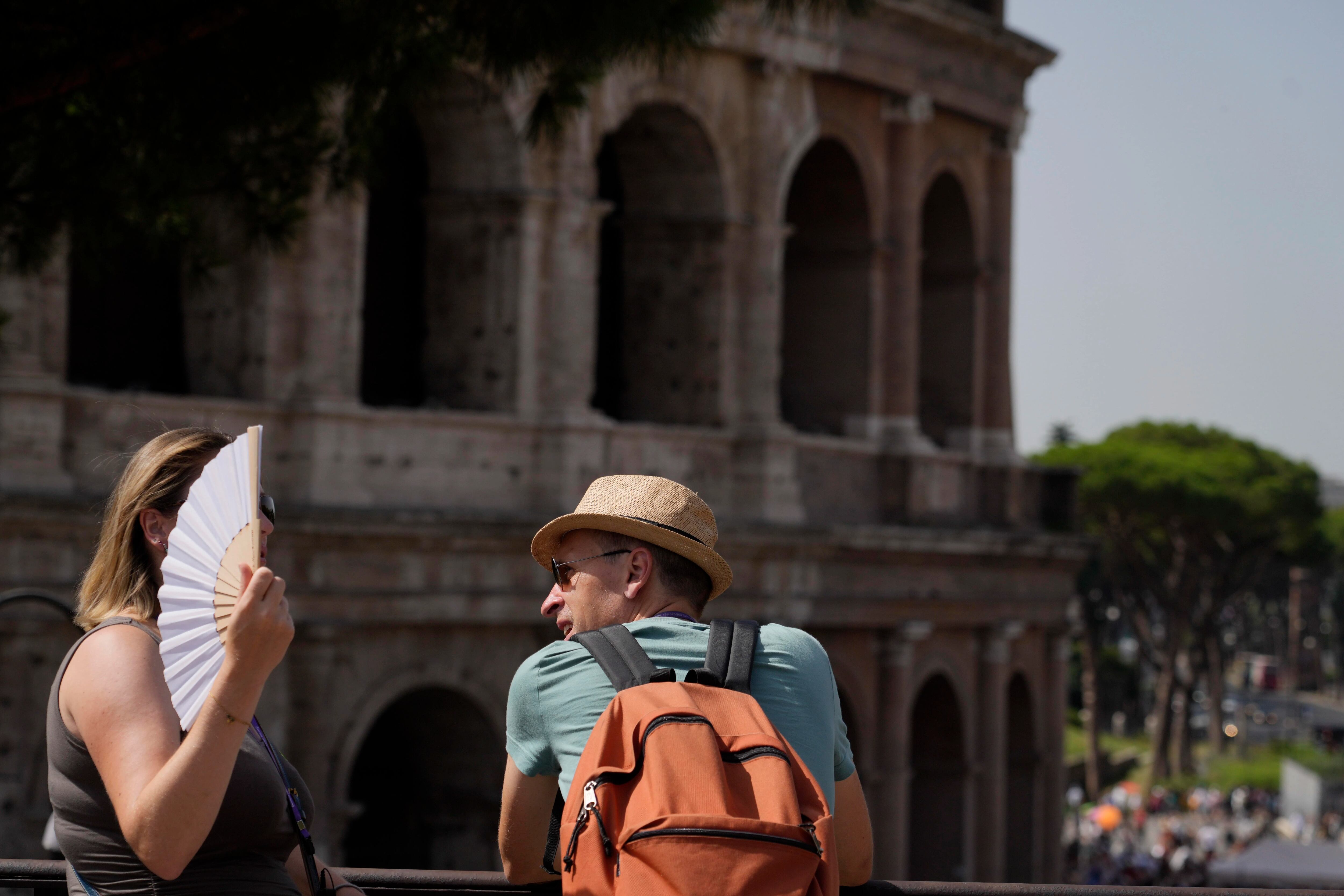 Turistas se detienen ante el Coliseo en Roma, el lunes 17 de julio de 2023. Las turistas visitaban el lunes la ciudad eterna, pese a una ola de calor que situaba Roma en la lista de las ciudades más calurosas del país. (AP Foto/Gregorio Borgia)