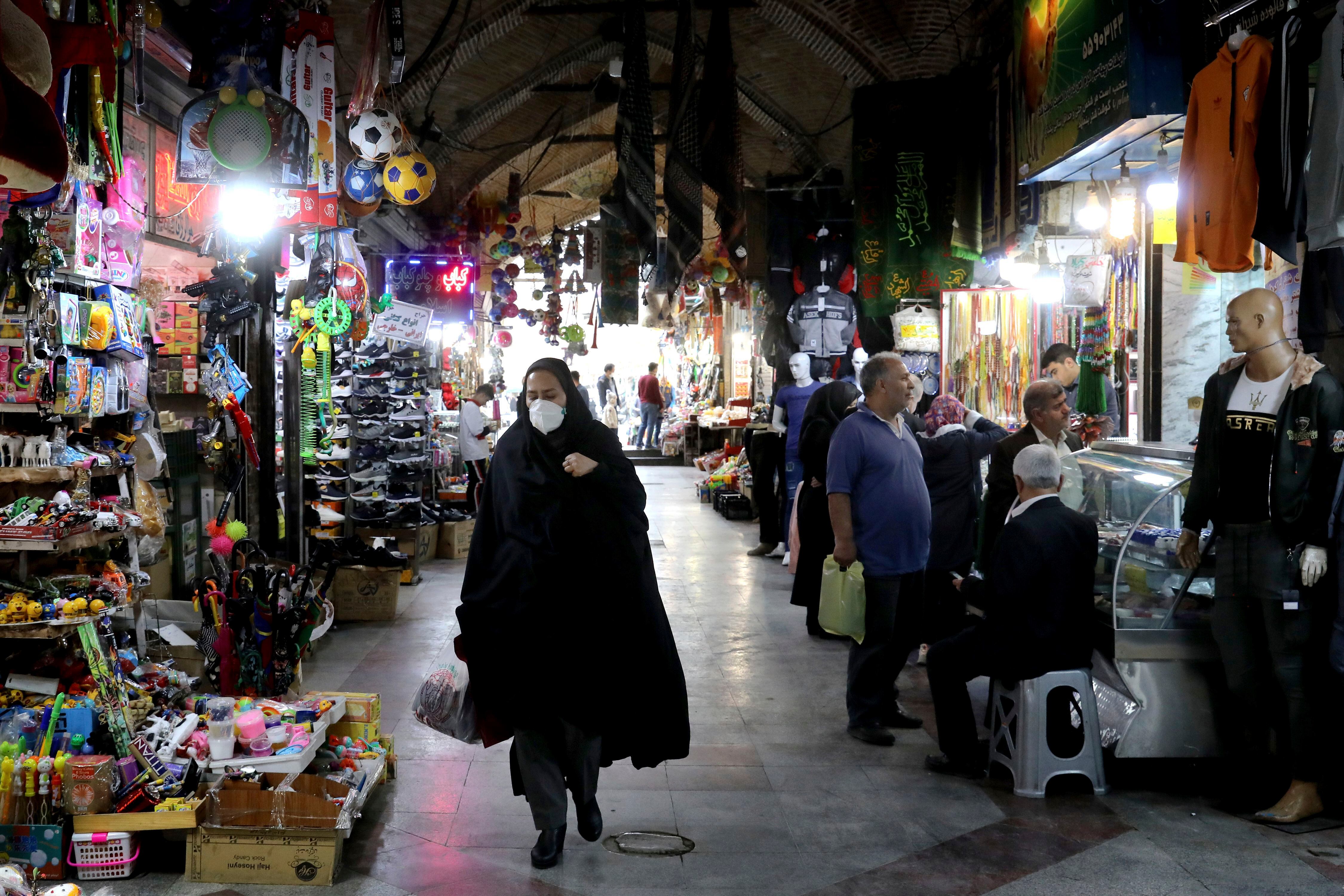 Una mujer camina por un mercado en Teherán A pedestrian wears a mask to help guard against the new Coronavirus (AP)