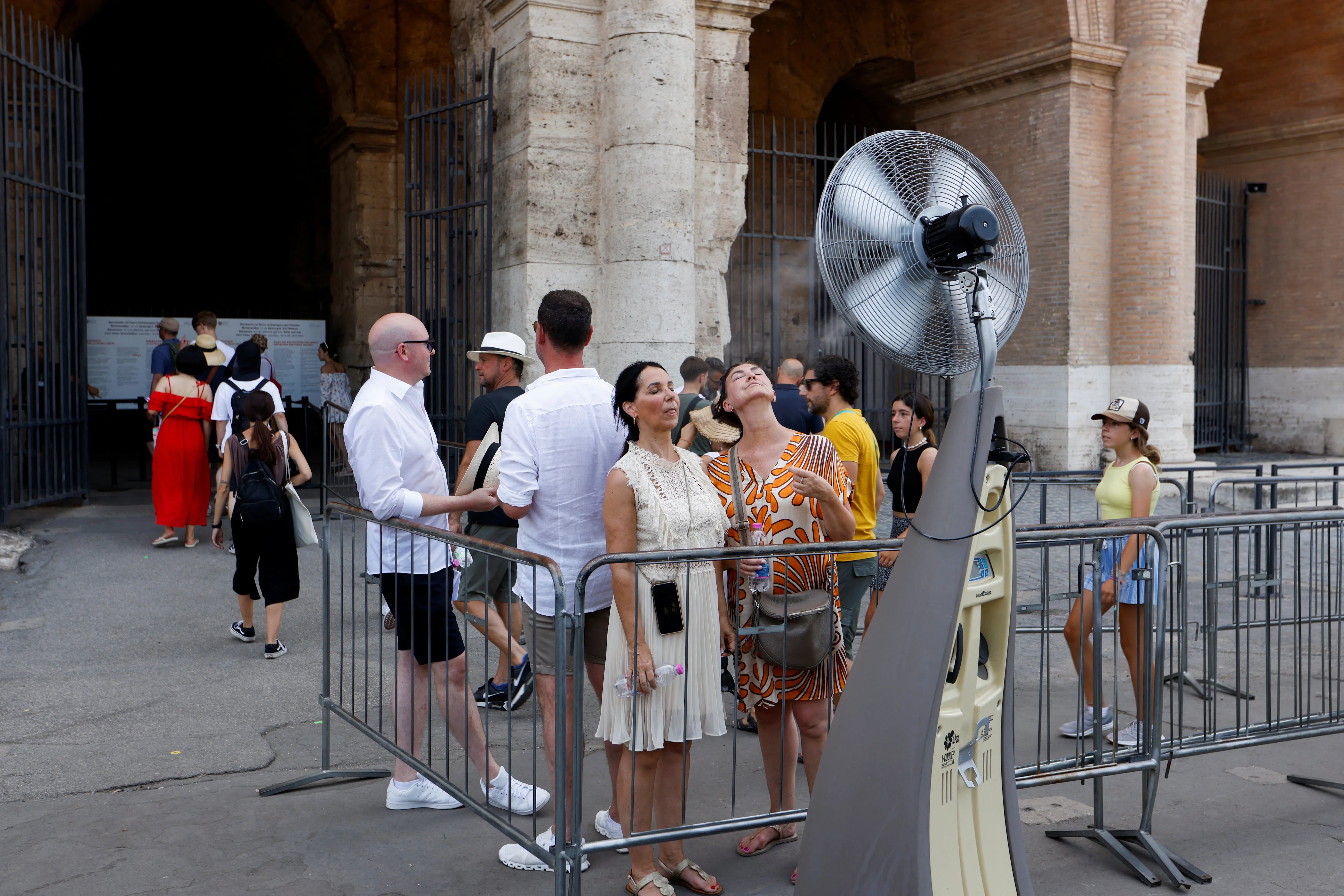 Turistas se refrescan antes de entrar en el Coliseo en Roma (REUTERS/Remo Casilli)