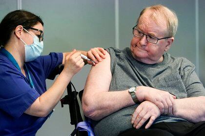 La enfermera Maria Golding vacuna a Svein Andersen, en Oslo, la primera persona en Noruega en recibir la vacuna contra el coronavirus, el 27 de diciembre de 2020. (Fredrik Hagen/NTB via AP)