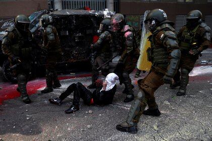 Agentes de la policía antidisturbios detienen a un manifestante durante una protesta contra el gobierno de Chile, en el primer aniversario de las protestas y disturbios que sacudieron la capital en 2019, en Santiago, Chile. REUTERS/Ivan Alvarado TPX IMAGES OF THE DAY