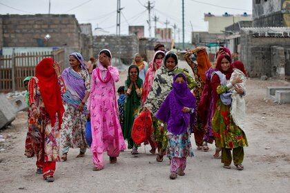 Mujeres y niños evacúan sus viviendas en Veraval, en el estado de Gujarat (Reuters)