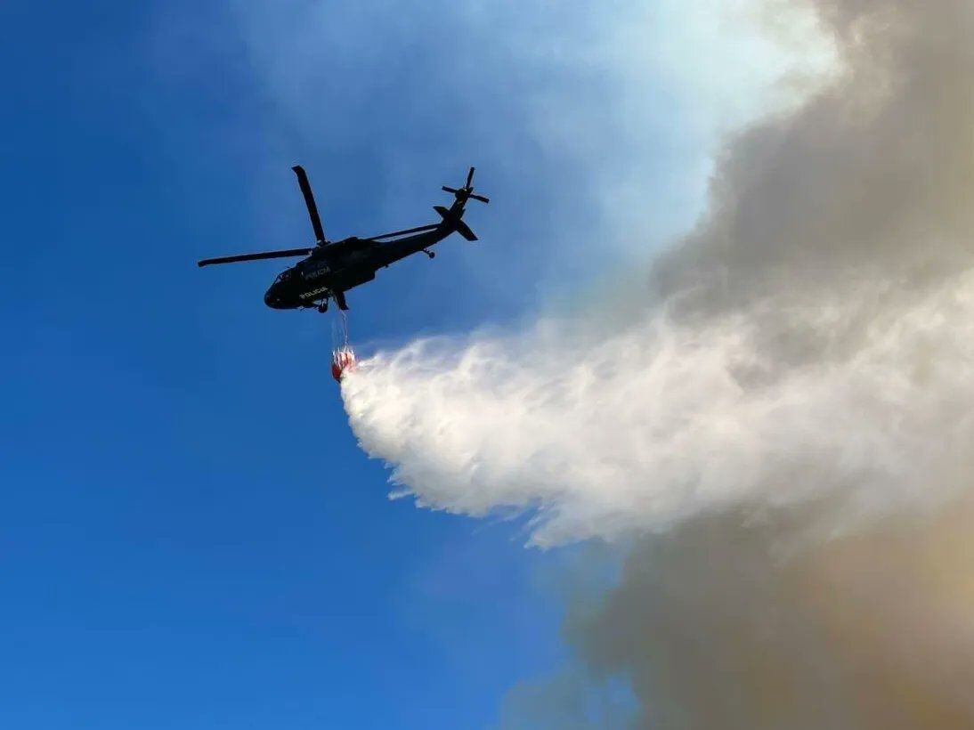Un helicóptero realiza descargas en la zona afectada este lunes - crédito Bomberos de Bogotá