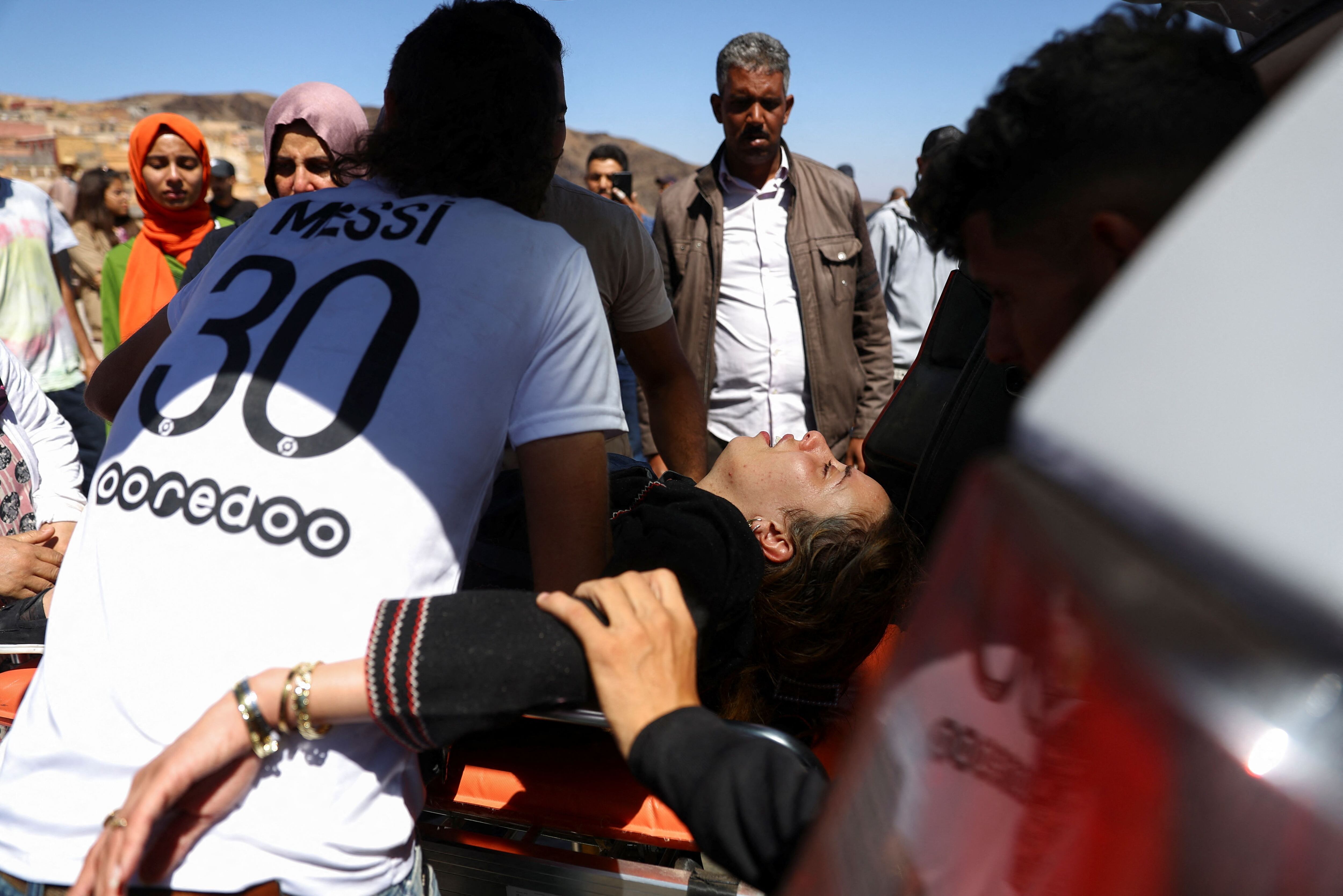 Varias personas ayudan a la hija de una víctimas del mortífero terremoto durante su funeral, en Moulay Brahim, Marruecos, 10 de septiembre de 2023. REUTERS/Hannah McKay