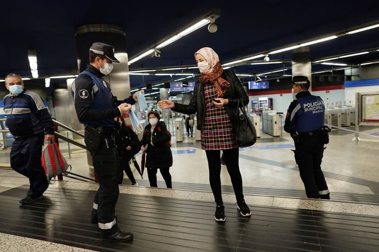 Un policía municipal reparte mascarillas de forma gratuita en una estación de metro durante el estado de alarma declarado a raíz del brote de coronavirus (en Madrid, España, el 13 de abril de 2020. REUTERS/Juan Medina